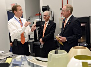 Martin Williams (left) 76th Commodities Maintenance Group engineering branch chief, shows parts made using 3-D printing technology in the Reverse Engineering and Critical Tooling cell to Dr. Charles Bunting, associate dean of Research and Sponsored Programs at Oklahoma State University and Dr. Burns Hargis, OSU president, during an Oct. 7, 2015, tour of OC-ALC engineering and software facilities. (U.S. Air Force photo/Kelly White) 